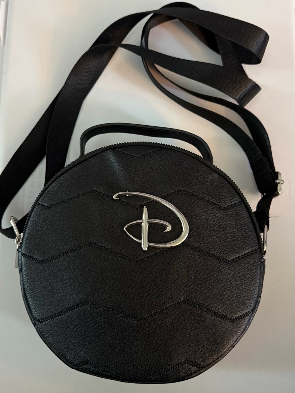 Black Round Crossbody Bag with Silver Emblem